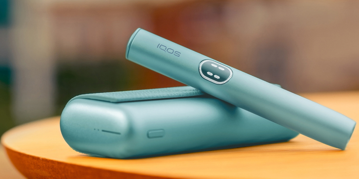 Blue IQOS ILUMA i PRIME device above its charger